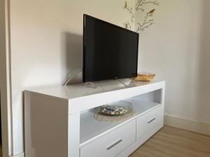 a white entertainment center with a flat screen tv on it at Finca Vistalpas in Mogro