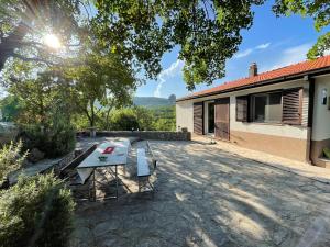 een patio met een picknicktafel voor een huis bij Holiday House Dunamis in Krivodol