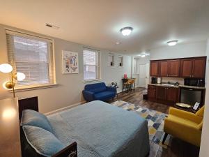 a bedroom with a bed and a couch and a kitchen at Cozy Studio at the Historic Inman in Champaign