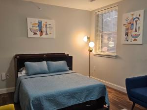 a bedroom with a bed with blue sheets and a window at Cozy Studio at the Historic Inman in Champaign