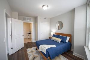 a bedroom with a blue bed and a mirror at Stylish 1 BR 1BA at The Inman in Champaign