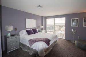 1 dormitorio con 1 cama con paredes de color púrpura y ventana en Luxury Condo in Downtown Champaign, en Champaign