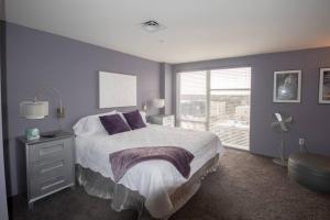 a bedroom with a bed with purple walls and a window at Luxury Condo in Downtown Champaign in Champaign