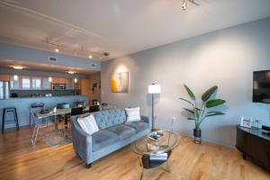 a living room with a blue couch and a table at Luxury Condo in Downtown Champaign in Champaign