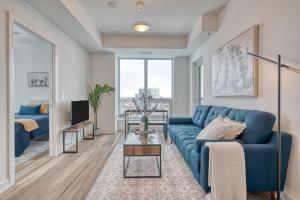 a living room with a blue couch and a tv at 2 Bedroom, 2 Bath Stunning Condo - heart of Kitchener Downtown in Kitchener