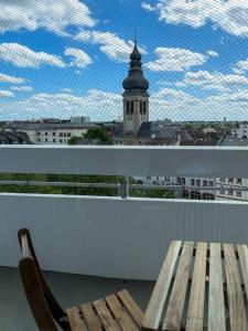 a bench on a balcony with a view of a building at Cosy flat with stunning view in Offenbach
