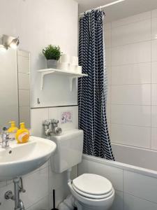 ein weißes Bad mit einem WC und einem Waschbecken in der Unterkunft Cosy flat with stunning view in Offenbach