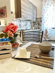 eine Küche mit einem Tisch mit einer Vase Rosen darauf in der Unterkunft La dimora di Sandy in Viterbo