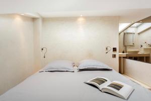 ein Schlafzimmer mit einem Bett mit zwei Büchern darauf in der Unterkunft Prestige sur Louvre et Tuileries in Paris