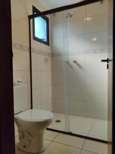 a bathroom with a toilet and a glass shower at Jaguaré Hotel in São Paulo