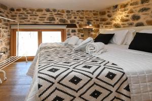 a bedroom with a bed with a black and white blanket at Palio Damnoni House in Damnoni
