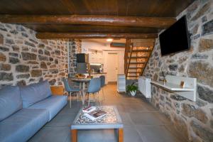 a living room with a blue couch and a stone wall at Palio Damnoni House in Damnoni