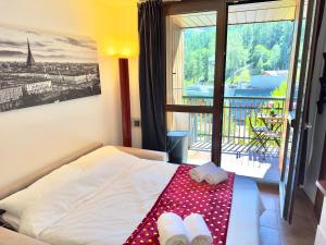 a hotel room with a bed with two towels and a balcony at [Paradiso di Montagna sulle piste da sci] in Bardonecchia