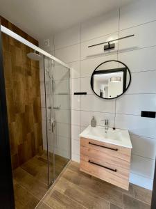 y baño con lavabo y espejo. en Apartamenty MarSyl en Jastrzębia Góra