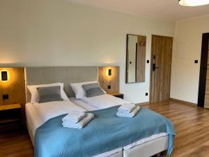 1 dormitorio con 1 cama grande y toallas. en Apartamenty MarSyl en Jastrzębia Góra