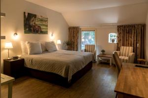ザイドラーレンにあるHotel B&B Hoeve de Vredenhofのベッドとテーブルが備わるホテルルームです。
