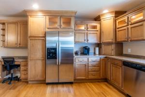 a kitchen with wooden cabinets and a stainless steel refrigerator at CozyLiving in Billings +26 photos