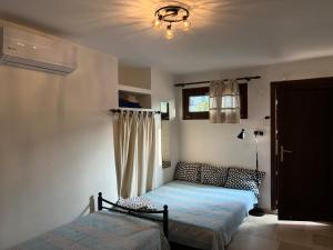 ネア・ムダニアにあるAM Beach Houseのベッドルーム1室(ベッド2台、窓付)