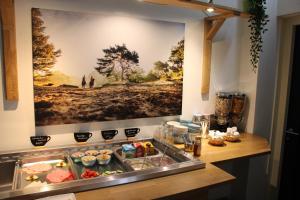 a kitchen with a large painting on the wall at Hotel B&B Hoeve de Vredenhof in Zuidlaren