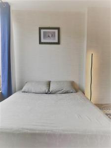 a bed in a bedroom with a picture on the wall at Le Cocon in Verrières