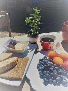 une table avec une assiette de pain au fromage et des fruits dans l'établissement Le Cocon, à Verrières