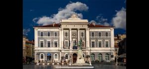 a large white building with a fountain in front of it at Apartment Hisa 7 Piran in Piran