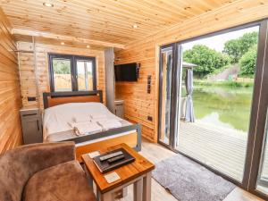 a bedroom with a bed and a large window at Oak Lodge At Bridge Lake Farm & Fishery in Banbury