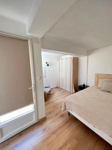 um quarto com uma cama e uma grande janela em Amiénoise 5 chambres proche Centre Ville em Amiens