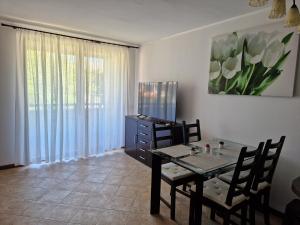 a dining room with a table and chairs and a painting at Apartment in the picturesque Oasis Resort & Spa in Lozenets