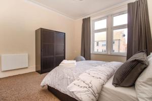 Un dormitorio con una cama grande y una ventana en The Ojay's - Gustina Apartment en Aberdeen