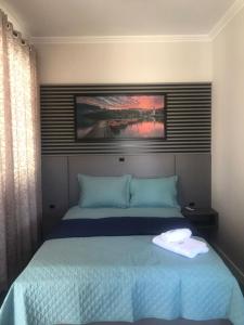 a bedroom with a large bed with blue sheets at Pousada Kaki Haus in Pomerode