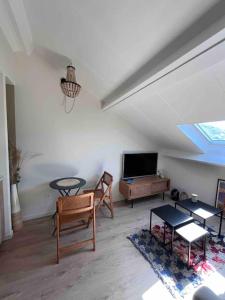 uma sala de estar com uma televisão e uma mesa e cadeiras em Casa Mariuccia em Algajola