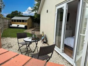 a patio with a table and chairs and a bedroom at The Gaol House, dog friendly! in Kinlet