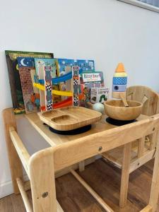 een houten tafel met twee kommen en boeken erop bij The Gaol House, dog friendly! in Kinlet