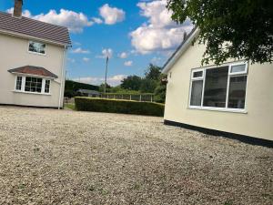 a house with a gravel driveway next to a building at The Gaol House, dog friendly! in Kinlet