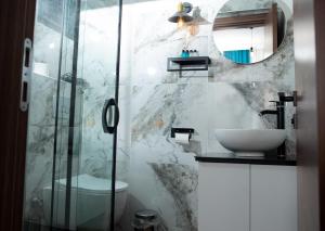 a bathroom with a sink and a toilet and a mirror at Mavi Yaprak Hotel in Oludeniz