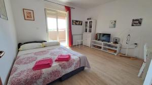 ein Schlafzimmer mit einem Bett mit zwei roten Handtüchern darauf in der Unterkunft Apartment Lucia in Marčana
