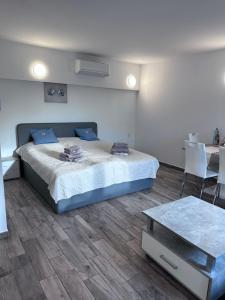 Schlafzimmer mit einem Bett und einem Tisch in der Unterkunft Sunny Apartments Podersdorf am See in Podersdorf am See