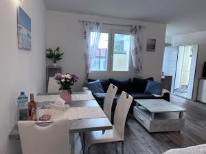 a living room with a table and a couch at Sunny Apartments Podersdorf am See in Podersdorf am See