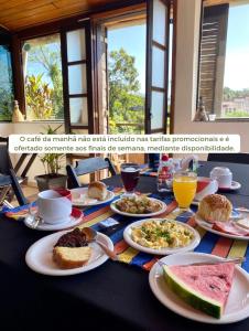 - une table avec des assiettes de nourriture et de boissons dans l'établissement Casa Petrópolis, à Petrópolis