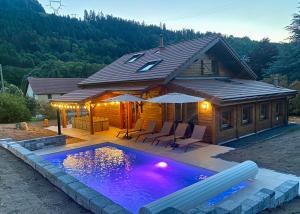 dom z basenem przed nim w obiekcie Gîte Chalet avec bain nordique et piscine 11 pers Hautes Vosges w mieście Plainfaing