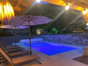 basen z dwoma krzesłami i parasolem w obiekcie Gîte Chalet avec bain nordique et piscine 11 pers Hautes Vosges w mieście Plainfaing +37 zdjęć