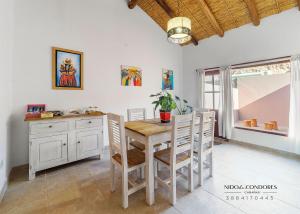 una sala da pranzo con tavolo e sedie in legno di Nido de cóndores a Purmamarca