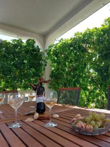 a bottle of wine sitting on a table with wine glasses at Apartman Skoko in Sevid