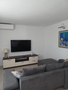 a living room with a couch and a flat screen tv at Apartman Skoko in Sevid