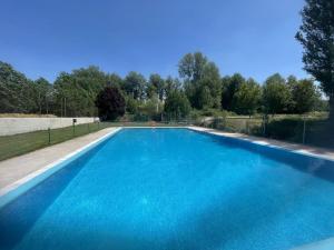 a large swimming pool with blue water at Apartamento Ribera del Duero Reserva in Tubilla del Lago