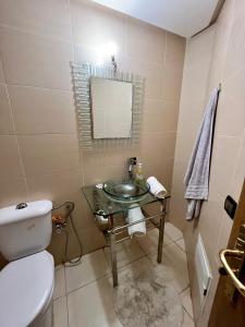 a bathroom with a sink and a toilet and a mirror at Asilah Marina Golf, Appartement au calme in Asilah
