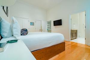 a white bedroom with a bed and a television at The Guesthouse Hotel in Chicago