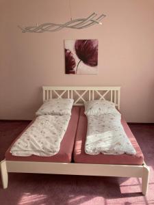 1 cama con 2 almohadas en una habitación en Villa Rosengarten, en Blankenburg