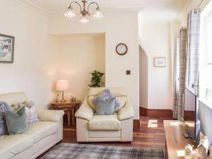 a living room with two white couches and a table at Sorbie Villa in Stevenston